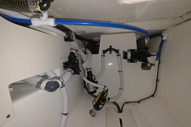 Slide: The Image of 2020 Mako 284 Center Console boat plumbing system with hoses and fittings. - 33