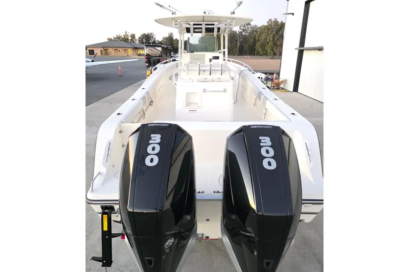 Slide: The Image of 2020 Mako 284 Center Console boat with dual Mercury 300 engines, docked outdoors. - 9