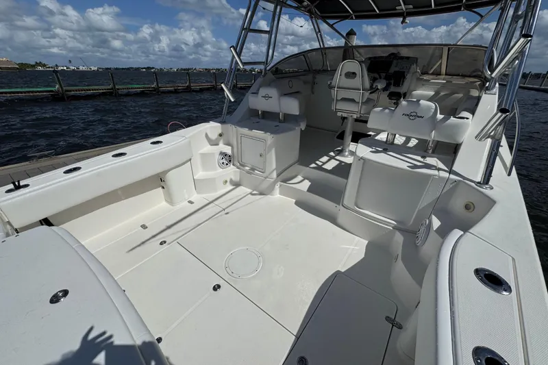 Slide: The Image of 2007 Fountain 33 Sportfish Cruiser boat interior with seating and helm, docked by the water. - 10