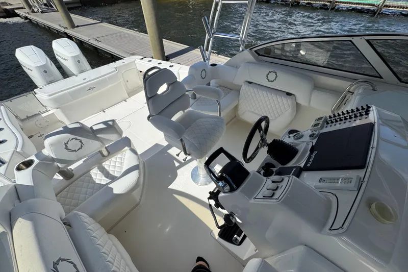 Slide: The Image of 2007 Fountain 33 Sportfish Cruiser interior with white seating and control panel. - 14