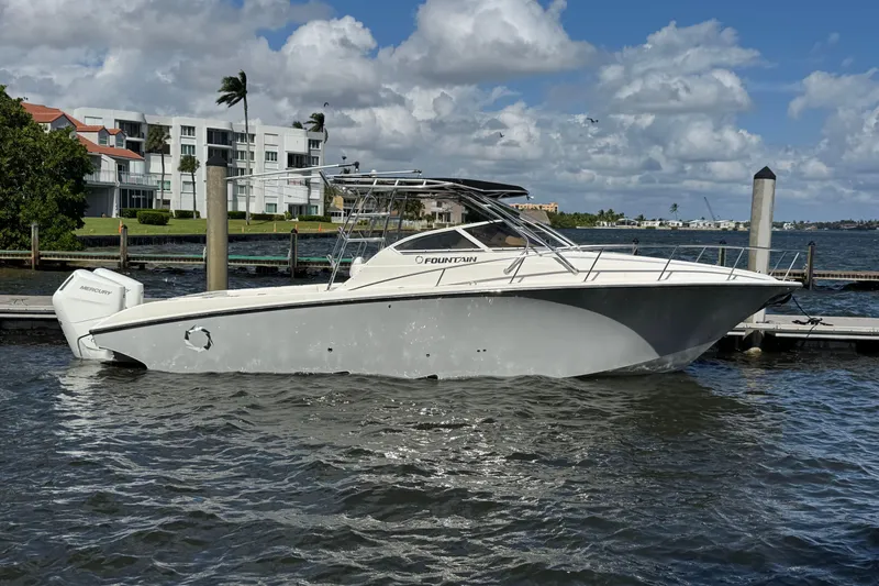 Slide: The Image of 2007 Fountain 33 Sportfish Cruiser docked by waterfront buildings under a cloudy sky. - 22
