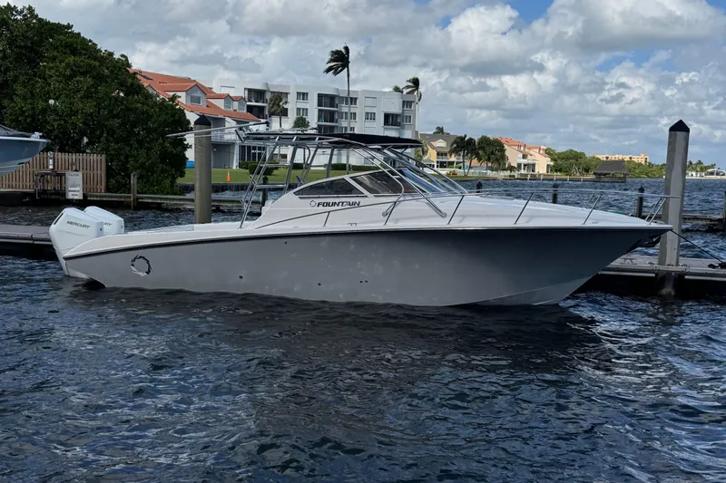 Slide: The Image of 2007 Fountain 33 Sportfish Cruiser docked by waterfront homes under cloudy sky. - 24