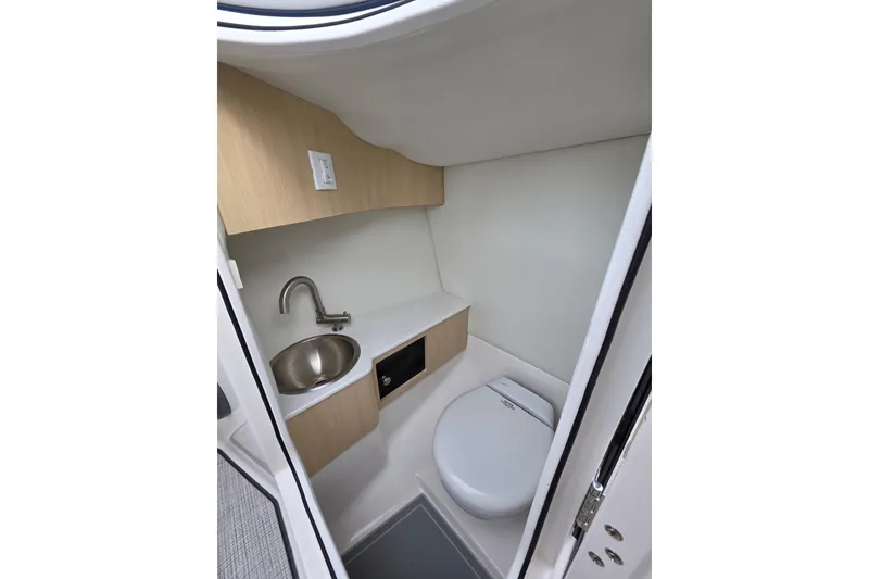 Slide: The Image of 2026 Regal LS6 boat interior with compact bathroom, featuring sink and toilet. - 10