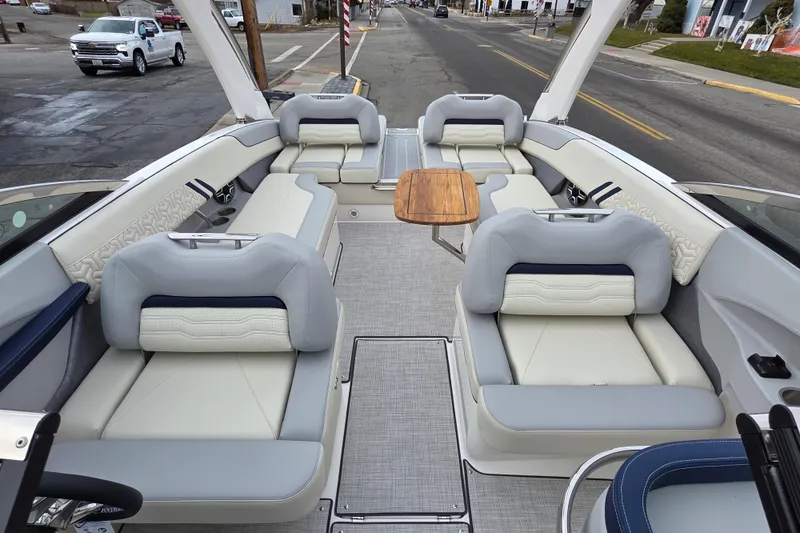 Slide: The Image of 2026 Regal LS6 boat interior with luxurious seating and wooden table on a city street. - 6