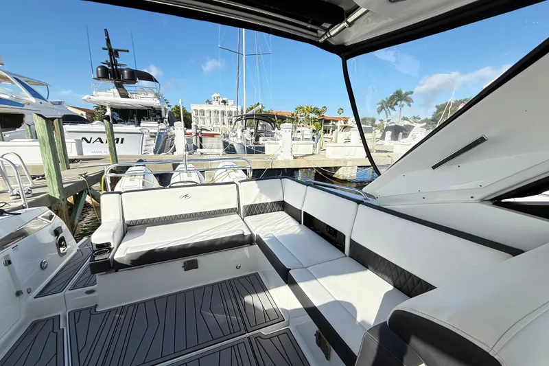 Slide: The Image of 2022 Monterey 385SS Super Sport boat interior at marina, featuring sleek seating and modern design. - 13