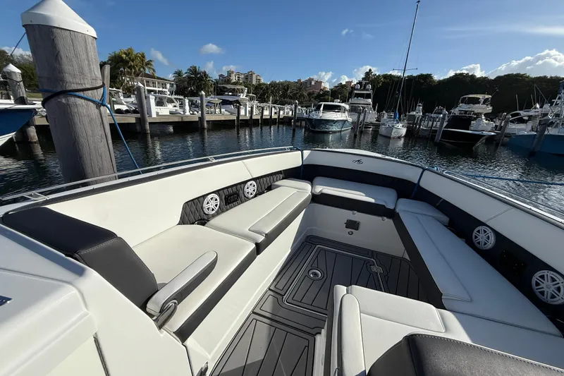 Slide: The Image of 2022 Monterey 385SS Super Sport boat interior at marina, featuring spacious seating and modern design. - 20