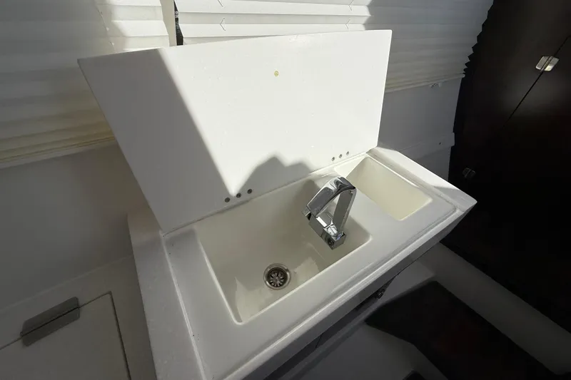 Slide: The Image of 2022 Monterey 385SS Super Sport boat sink with modern faucet and white countertop. - 32