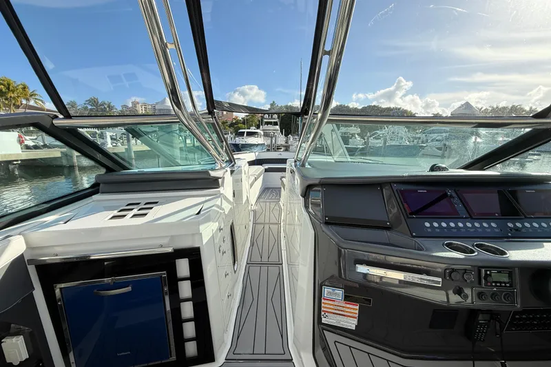 Slide: The Image of 2022 Monterey 385SS Super Sport boat interior with modern dashboard and marina view. - 44