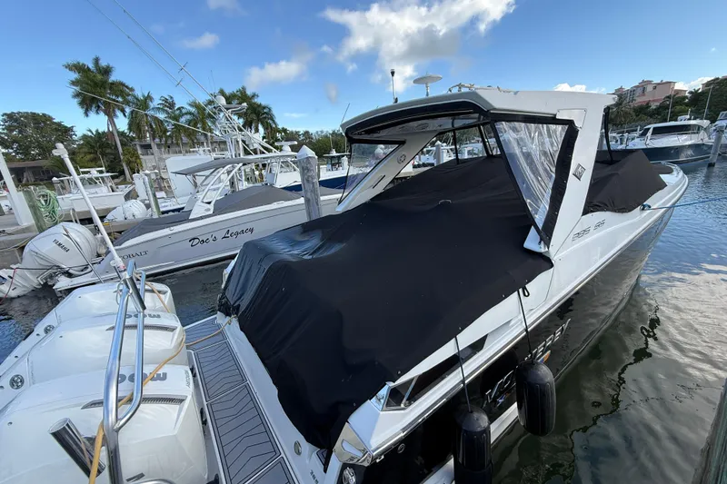 Slide: The Image of 2022 Monterey 385SS Super Sport boat docked at marina with cover, surrounded by other boats. - 57