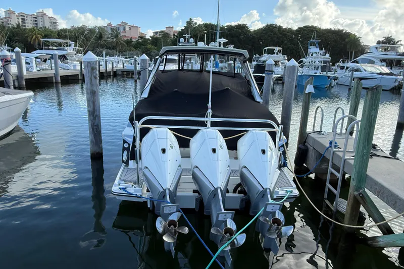 Slide: The Image of 2022 Monterey 385SS Super Sport boat docked at marina with triple outboard engines. - 61