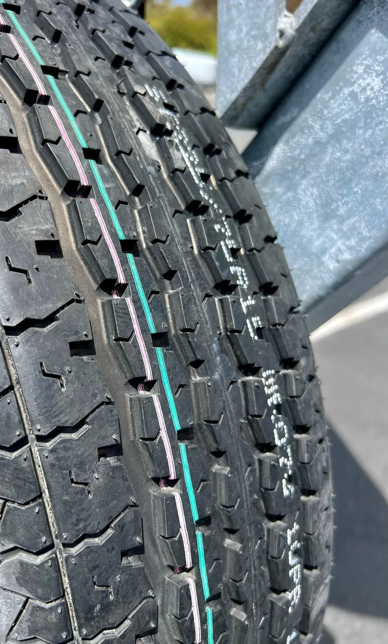 Slide: The Image of Close-up of a tire tread on a 2019 Regal 26 XO boat trailer. - 23