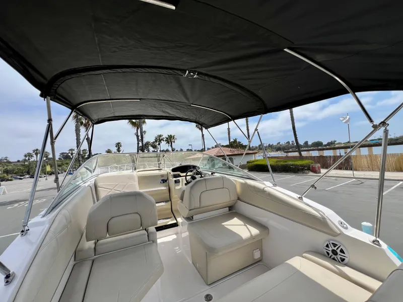 Slide: The Image of 2019 Regal 26 XO boat interior with canopy, featuring seating and steering wheel. - 25