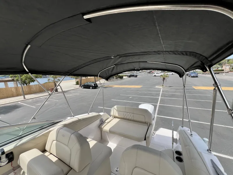 Slide: The Image of 2019 Regal 26 XO boat interior with canopy, parked in a lot. - 26