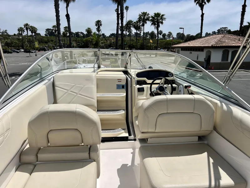 Slide: The Image of 2019 Regal 26 XO boat interior with beige seating, steering wheel, and clear windshield. - 30