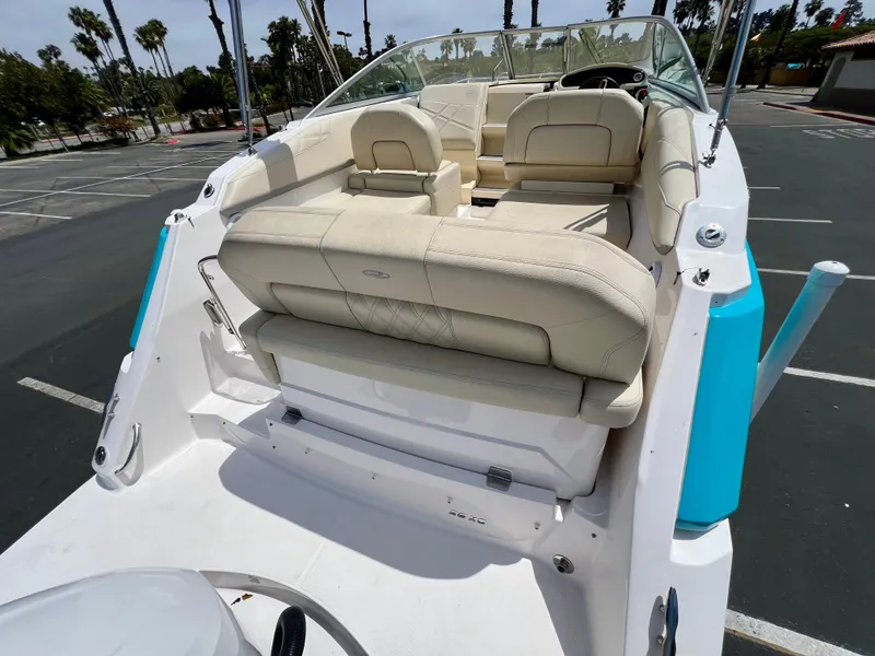 Slide: The Image of 2019 Regal 26 XO boat with beige seating, parked in a lot, palm trees in background. - 31