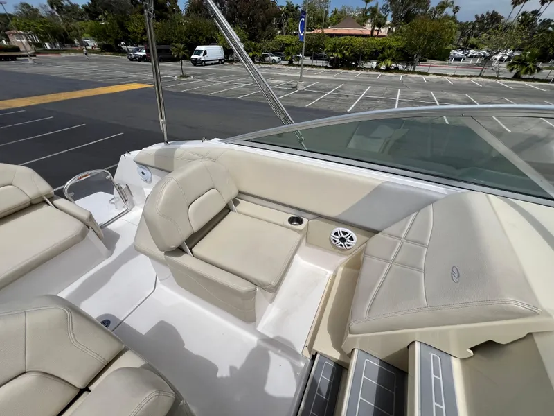 Slide: The Image of 2019 Regal 26 XO boat interior with beige seating in a parking lot. - 34