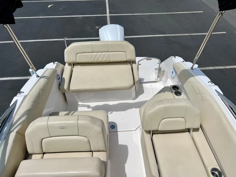 Slide: The Image of 2019 Regal 26 XO boat interior with beige seating in a parking lot. - 36