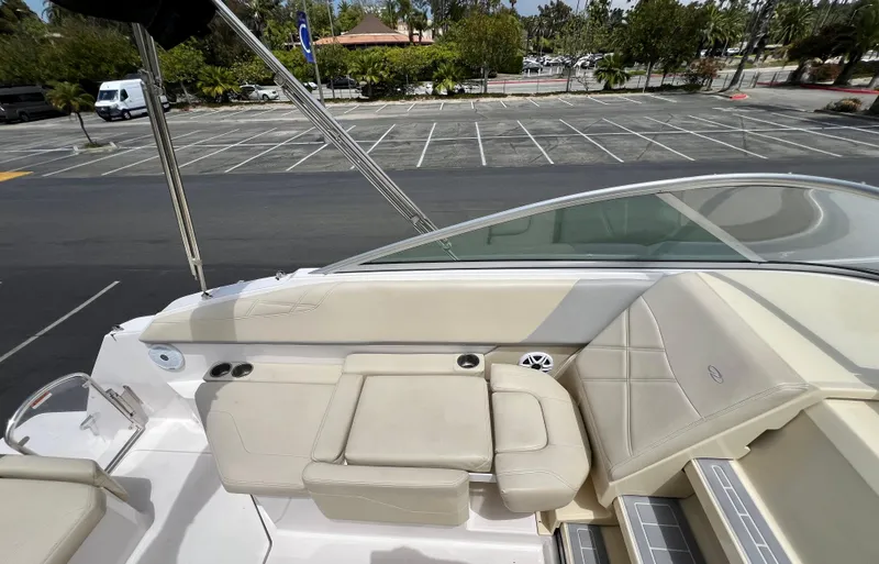 Slide: The Image of 2019 Regal 26 XO boat interior with beige seating in a parking lot setting. - 37