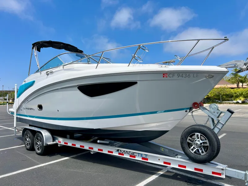 Slide: The Image of 2019 Regal 26 XO boat on trailer in parking lot under blue sky. - 4