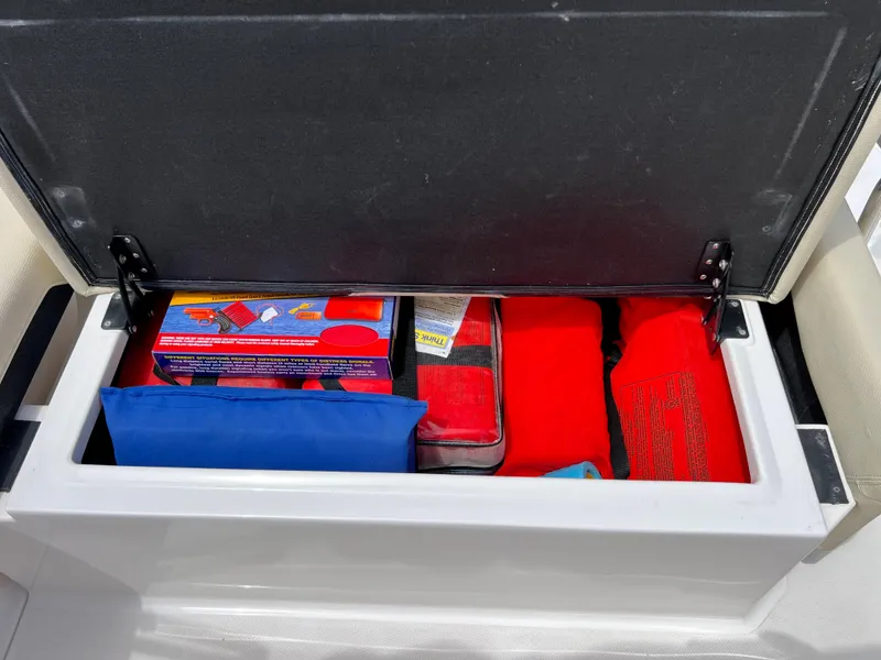 Slide: The Image of Storage compartment in a 2019 Regal 26 XO boat, containing safety equipment and supplies. - 41
