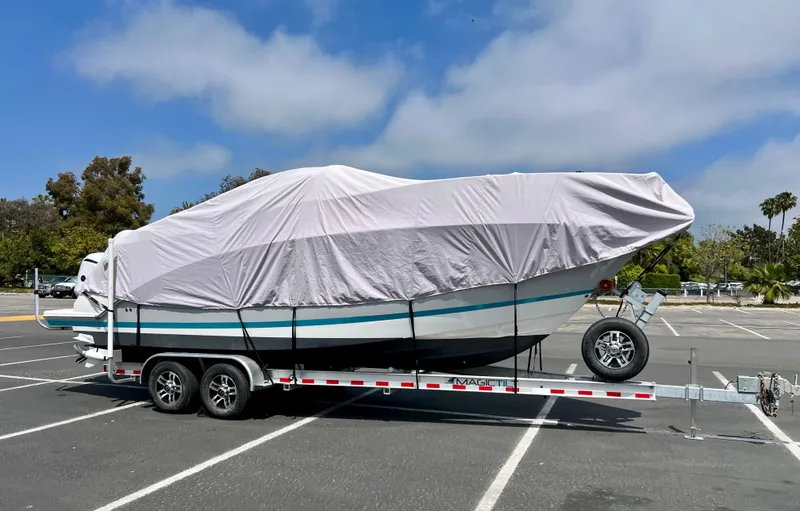 Slide: The Image of Covered 2019 Regal 26 XO boat on trailer in parking lot. - 45