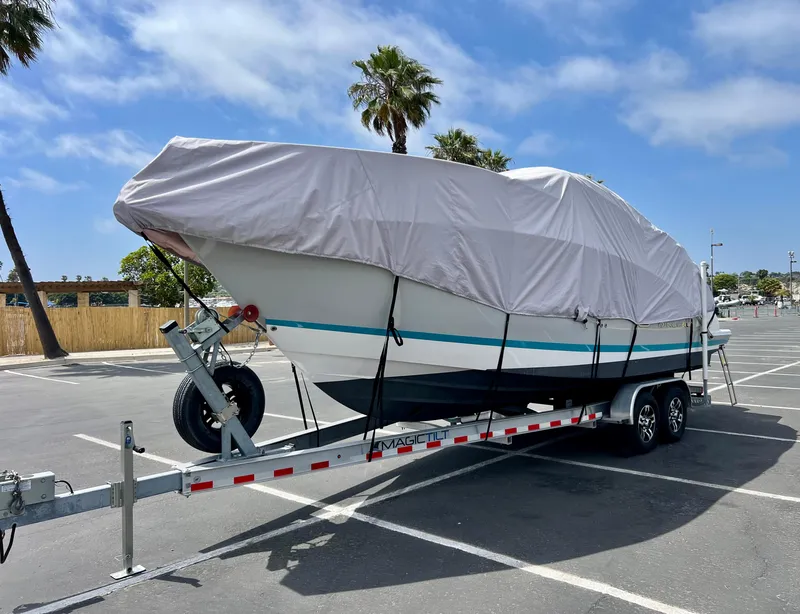 Slide: The Image of Covered 2019 Regal 26 XO boat on trailer in parking lot with palm trees. - 46