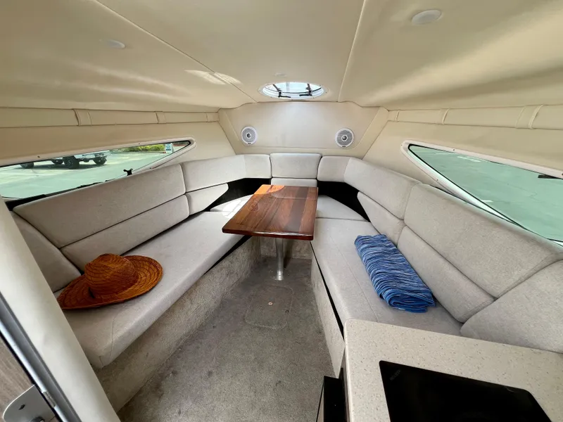 Slide: The Image of 2019 Regal 26 XO cabin interior with seating, table, hat, and blanket. - 47