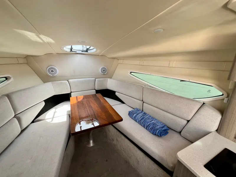 Slide: The Image of 2019 Regal 26 XO cabin interior with beige seating and wooden table. - 48