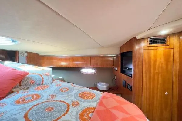 Slide: The Image of Luxurious cabin interior of 2005 Cruisers 420 yacht with cozy bedding and wood paneling. - 25