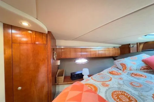 Slide: The Image of 2005 Cruisers 420 yacht cabin with wood paneling and patterned bedding. - 27