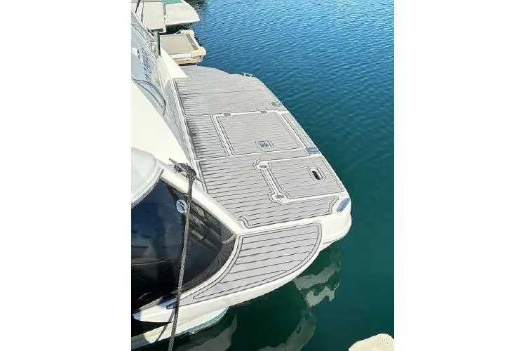 Slide: The Image of 2005 Cruisers 420 yacht docked, featuring a spacious swim platform on calm water. - 32
