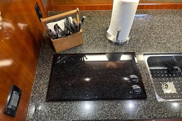 Slide: The Image of Modern kitchen countertop with stove, sink, and utensils on a 2005 Cruisers 420 yacht. - 17