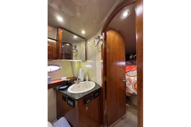 Slide: The Image of Luxurious 2005 Cruisers 420 yacht bathroom with sink, mirror, and wooden cabinetry. - 20