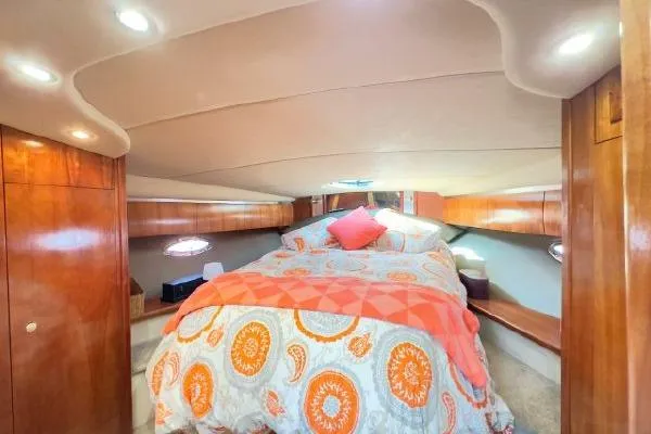Slide: The Image of Luxurious 2005 Cruisers 420 yacht cabin with cozy bedding and elegant wood finishes. - 24