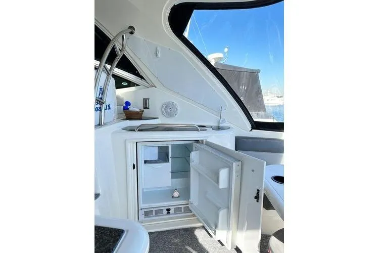 Slide: The Image of 2005 Cruisers 420 yacht interior with open mini fridge and sleek design. - 33