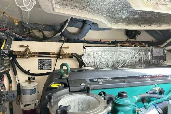 Slide: The Image of Engine room of a 2005 Cruisers 420 yacht, showcasing mechanical components and wiring. - 49