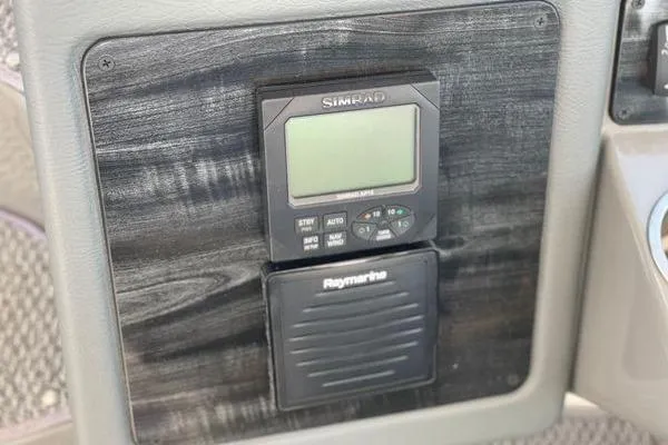 Slide: The Image of Control panel of a 2005 Cruisers 420 boat featuring Simrad and Raymarine devices. - 55
