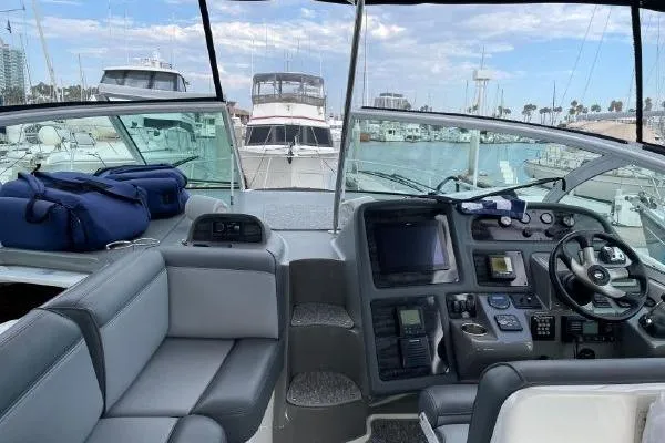 Slide: The Image of 2005 Cruisers 420 yacht cockpit with modern controls, docked in a marina. - 6