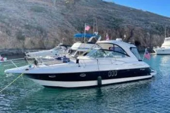 Slide: The Image of 2005 Cruisers 420 yacht docked in a scenic harbor with other boats. - 63