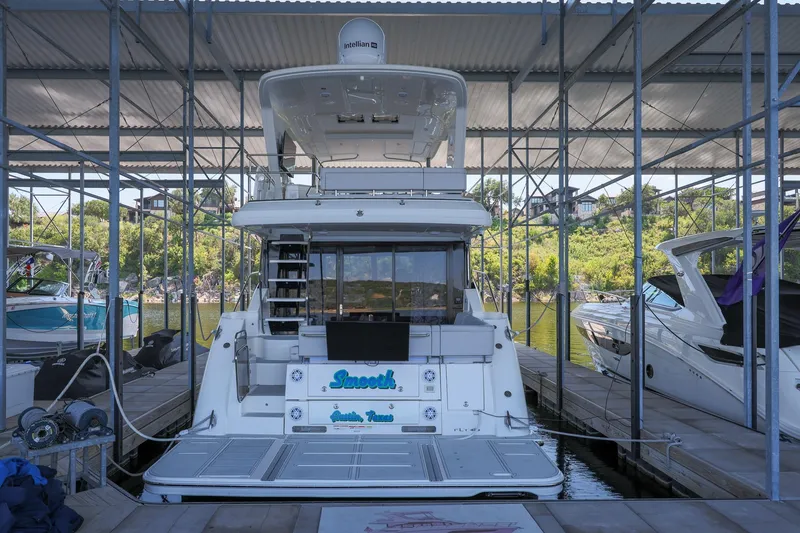 Slide: The Image of 2018 Sea Ray Fly 460 yacht docked in a marina, surrounded by other boats. - 29