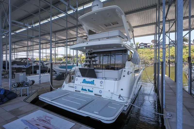 Slide: The Image of 2018 Sea Ray Fly 460 yacht docked in a covered marina. - 30