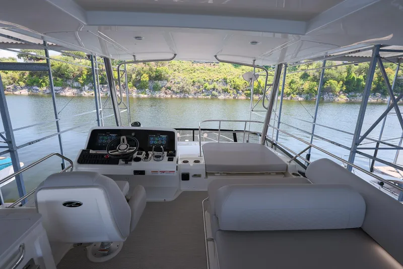 Slide: The Image of 2018 Sea Ray Fly 460 yacht interior with helm, seating, and scenic water view. - 51