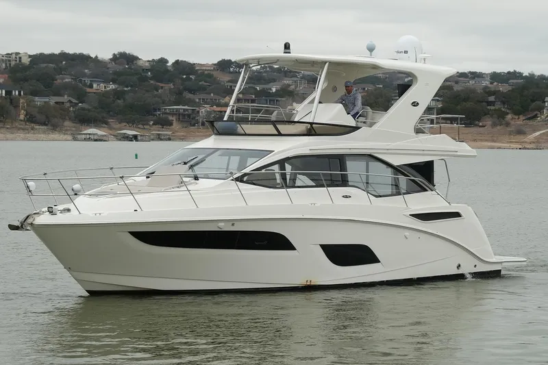 Slide: The Image of 2018 Sea Ray Fly 460 yacht cruising on a calm lake with scenic background. - 7