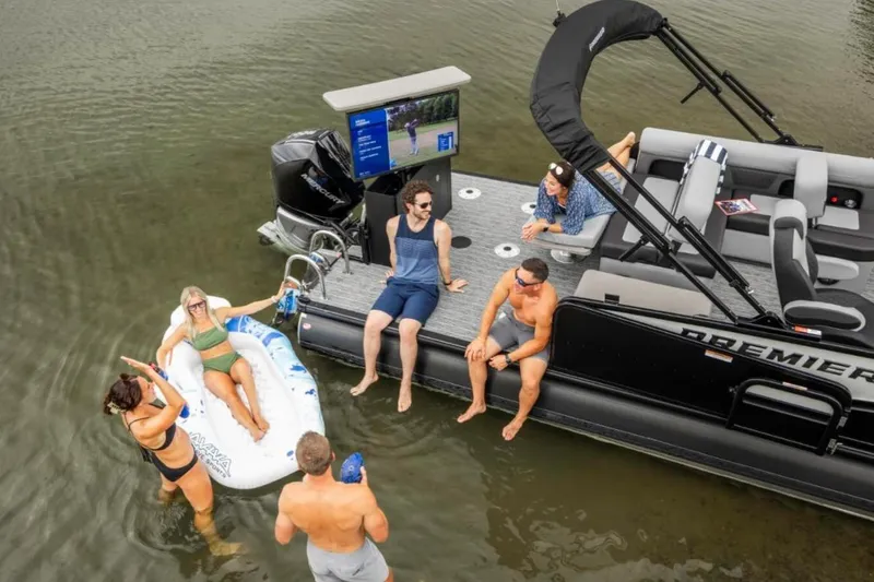 Slide: The Image of 2026 Premier 250 Solaris RS pontoon boat in a showroom, showcasing sleek design and luxury seating. - 12
