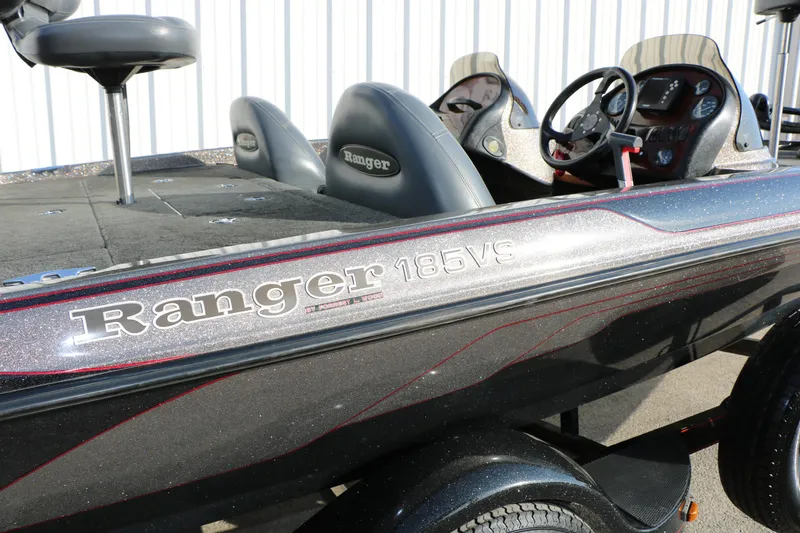 Slide: The Image of 2004 Ranger 185 VS boat with dual consoles and seating, parked outdoors. - 38