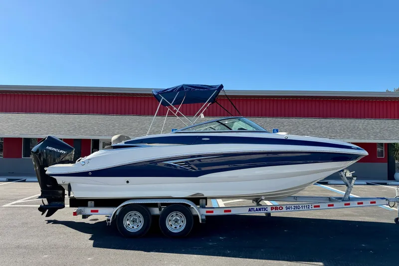 Slide: The Image of 2023 Crownline Eclipse E235 XS boat on trailer, parked outdoors. - 1