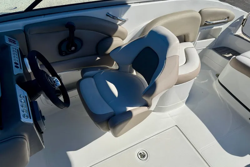 Slide: The Image of 2023 Crownline Eclipse E235 XS boat interior with steering wheel and cushioned seating. - 11