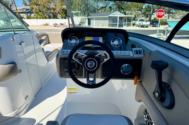 Slide: The Image of 2023 Crownline Eclipse E235 XS boat dashboard with steering wheel and controls. - 12