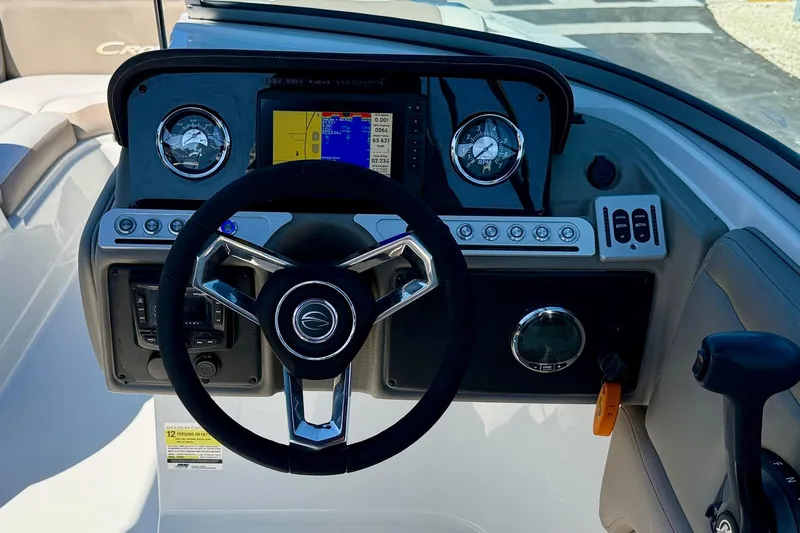 Slide: The Image of 2023 Crownline Eclipse E235 XS boat dashboard with steering wheel and control panel. - 13
