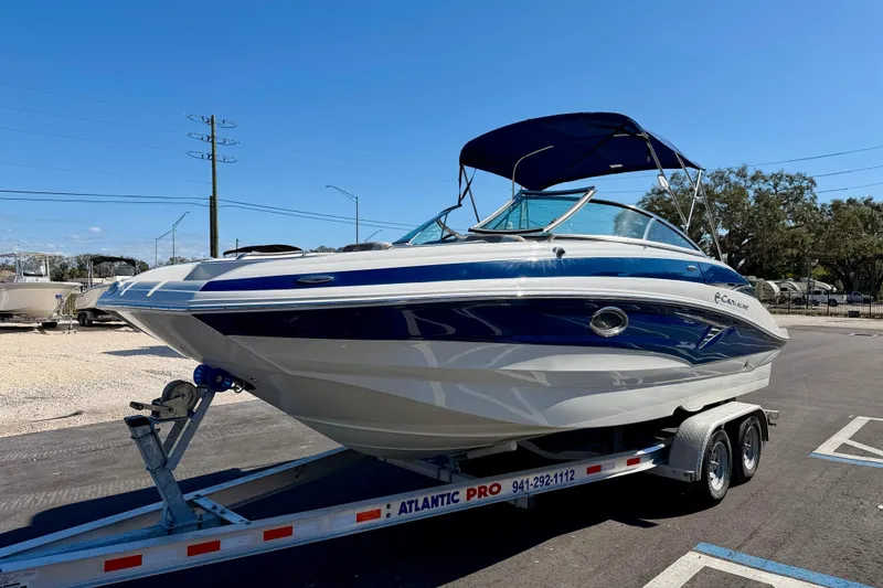 Slide: The Image of 2023 Crownline Eclipse E235 XS boat on trailer under clear blue sky. - 2